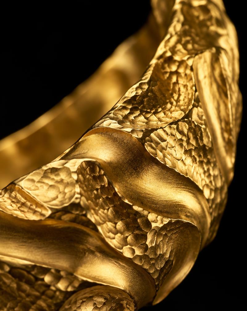 Macro detail of the collar's hand-worked gold texture